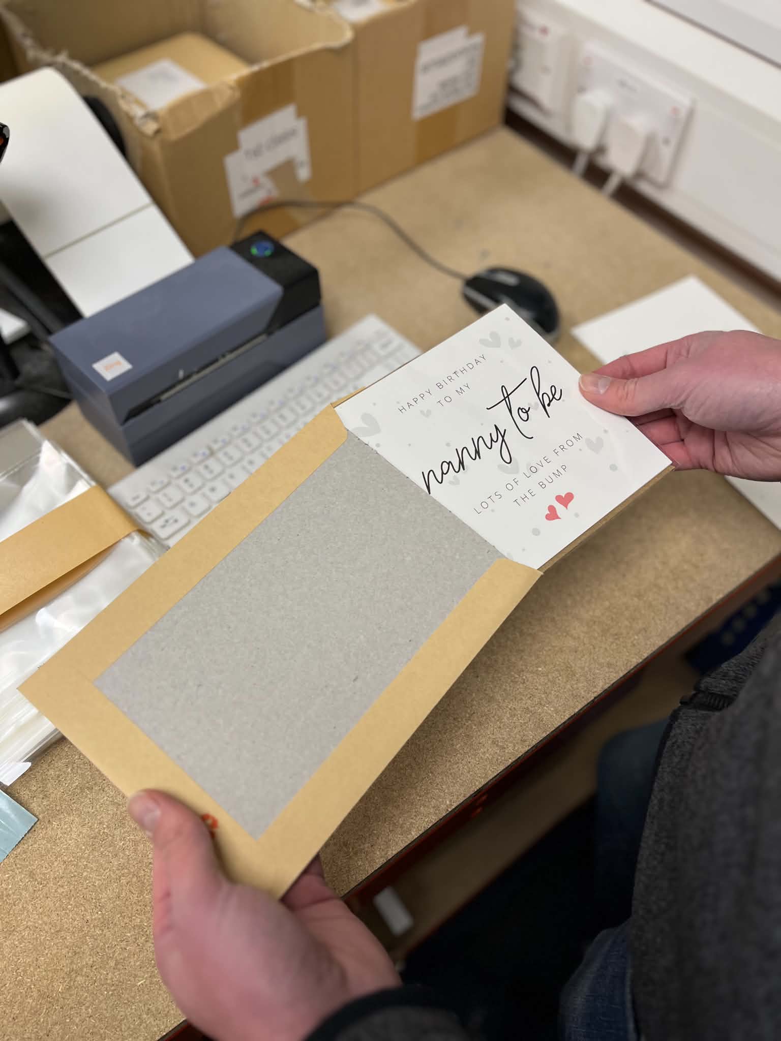 A Connect greeting card being packed with its envelope into a hardback mailer