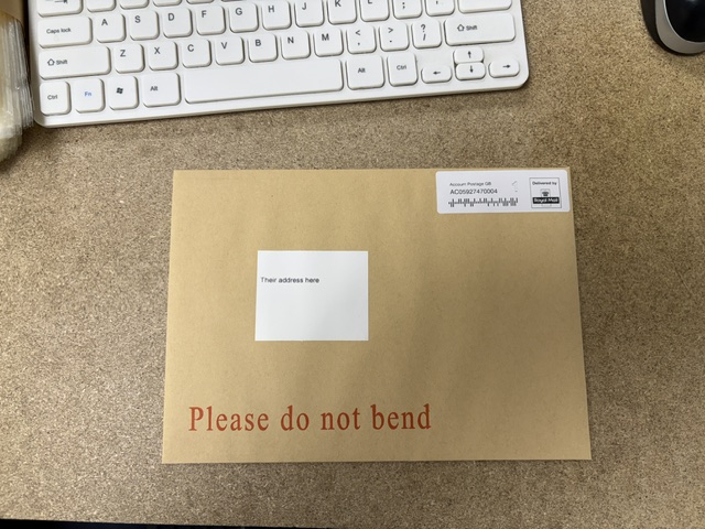 Hardback outer envelope showing the delivery address and Royal Mail postage label